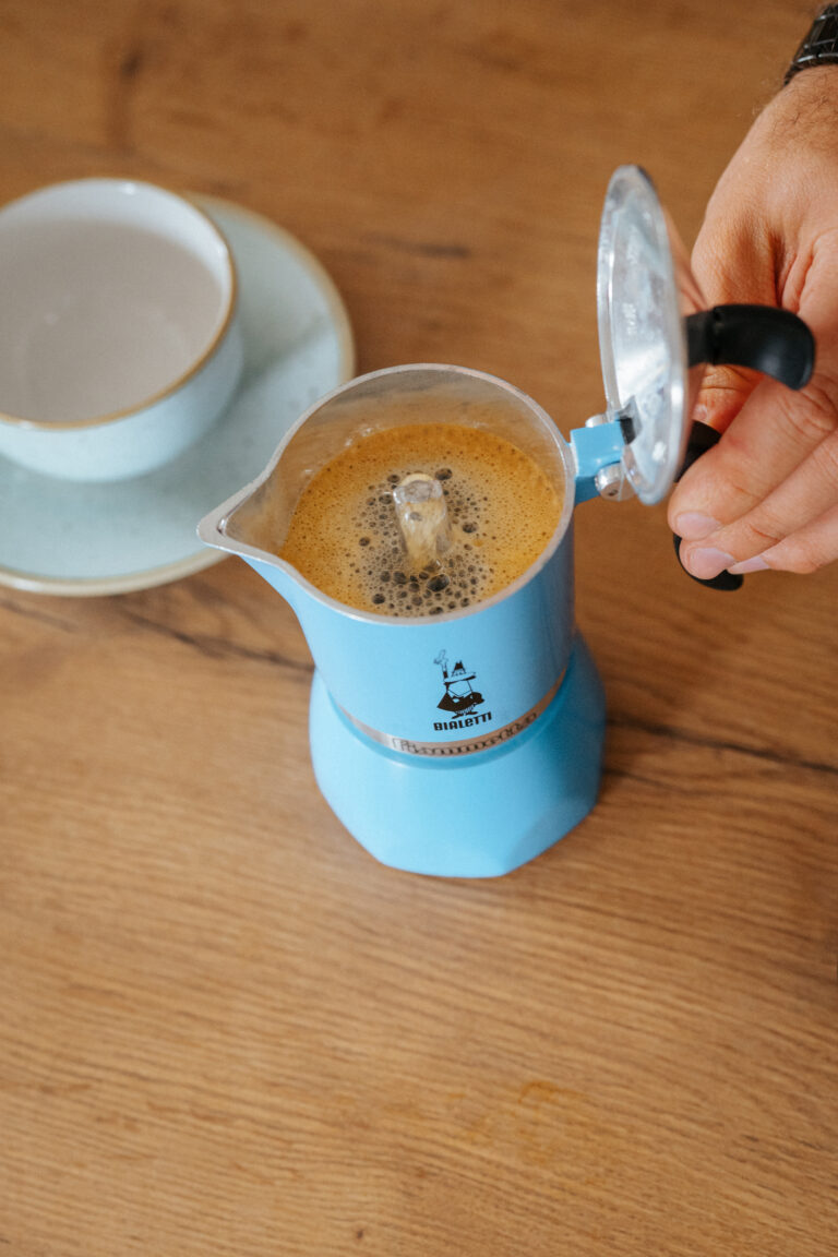 Barista otwiera kawiarkę z przygotowaną w środku kawą. 