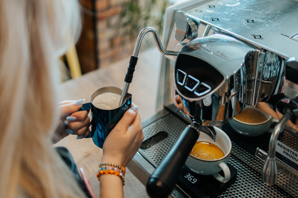 baristka parząca kawę w ekspresie kolbowym. ekspes kolbowy czy automatyczny